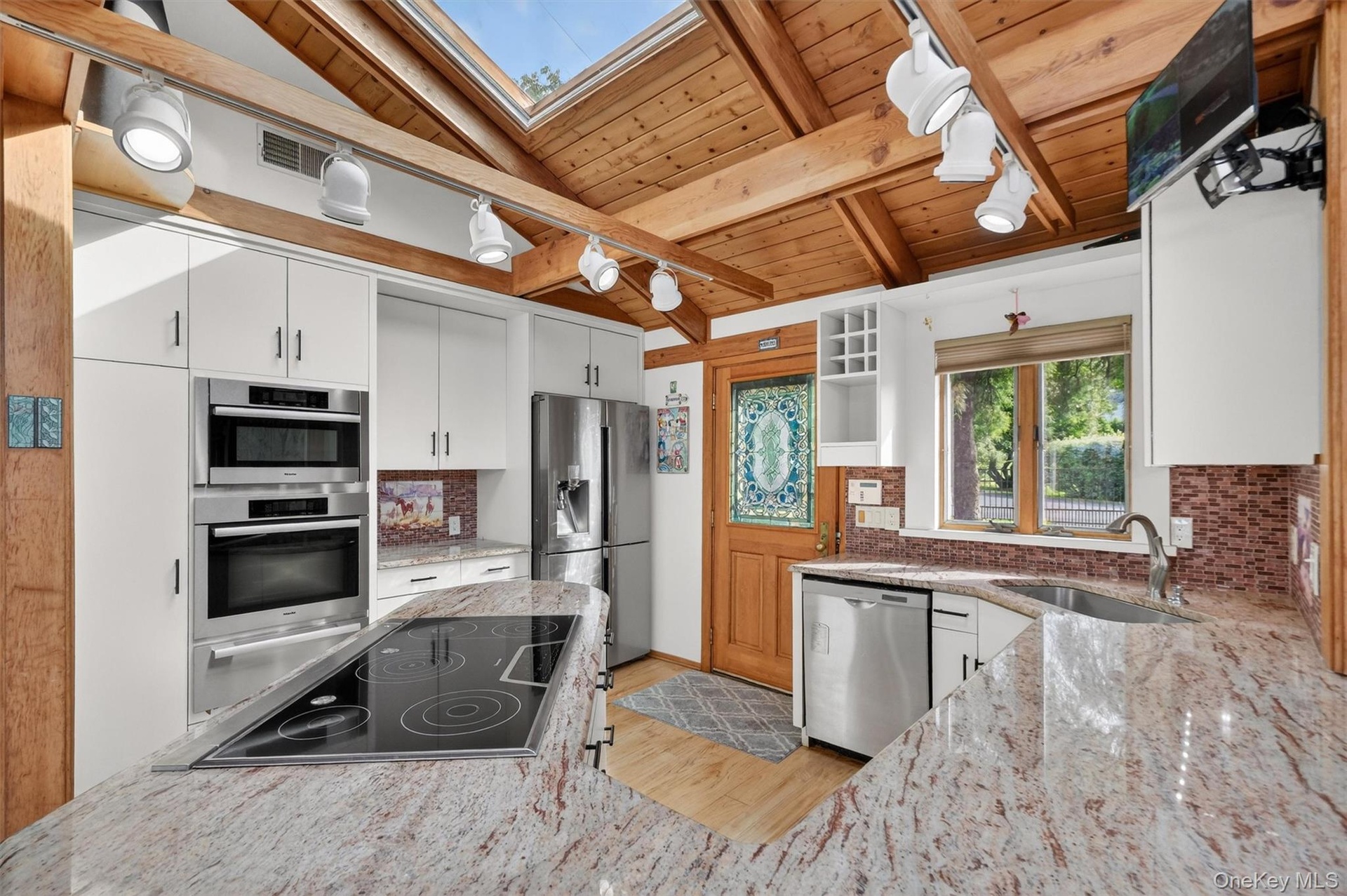 Backdoor guests are best!  Friends and family will enter through the open concept kitchen which features top tier appliances and skylights