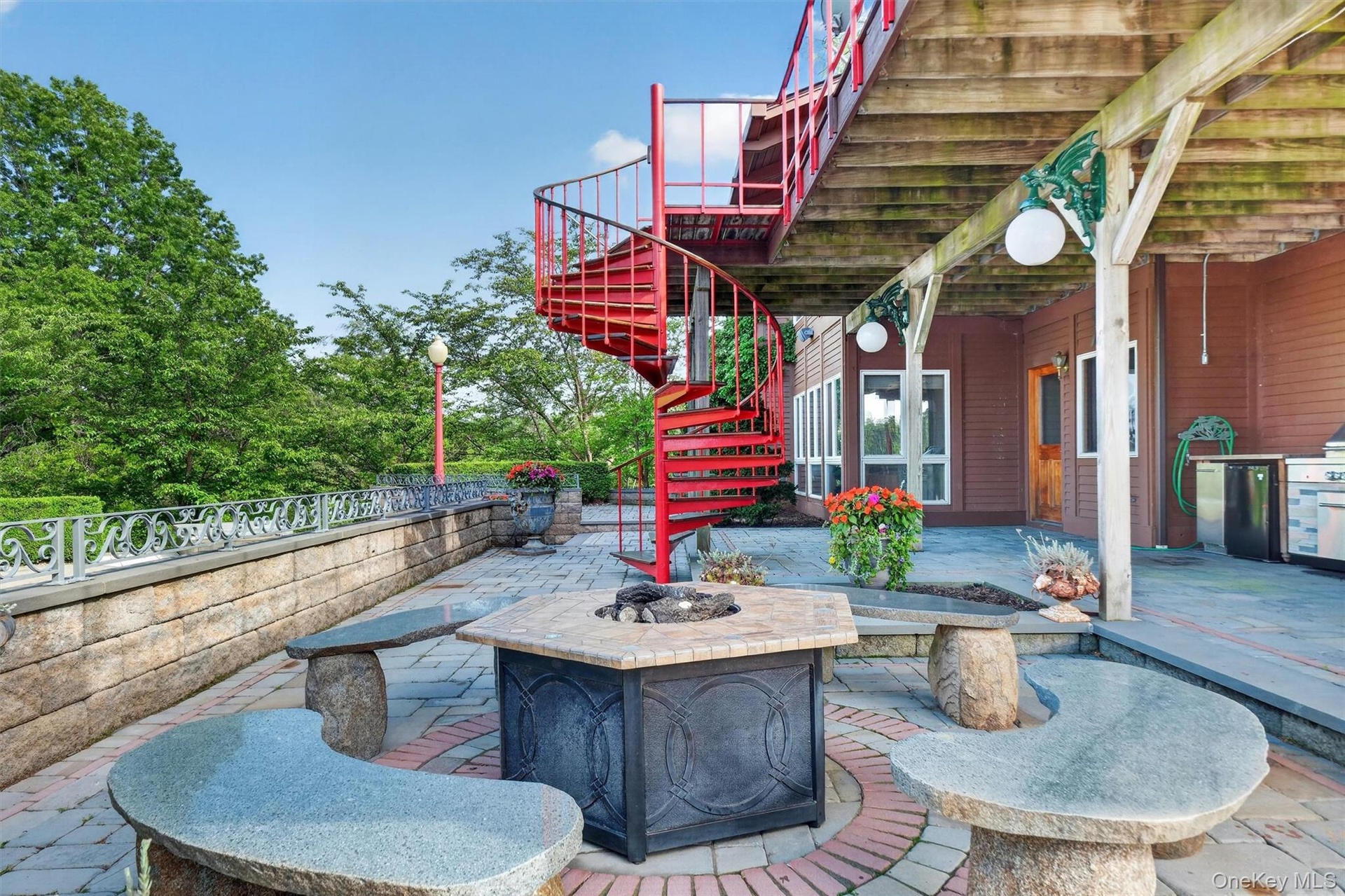 Beautiful stone, tile and granite carved fire pit area by the pool.  Note the spiral staircase from the top deck