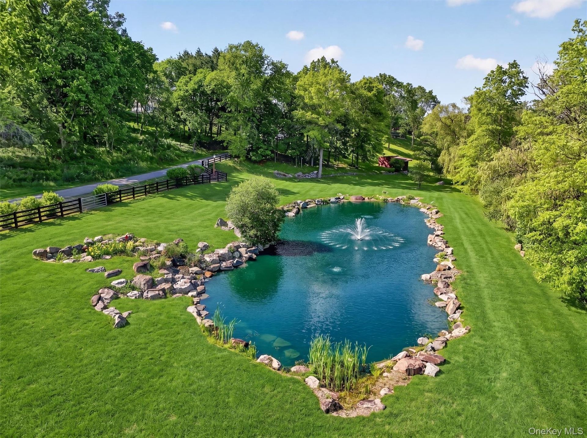 The largest of 3 koi ponds creates a park like feeling as you enter the property