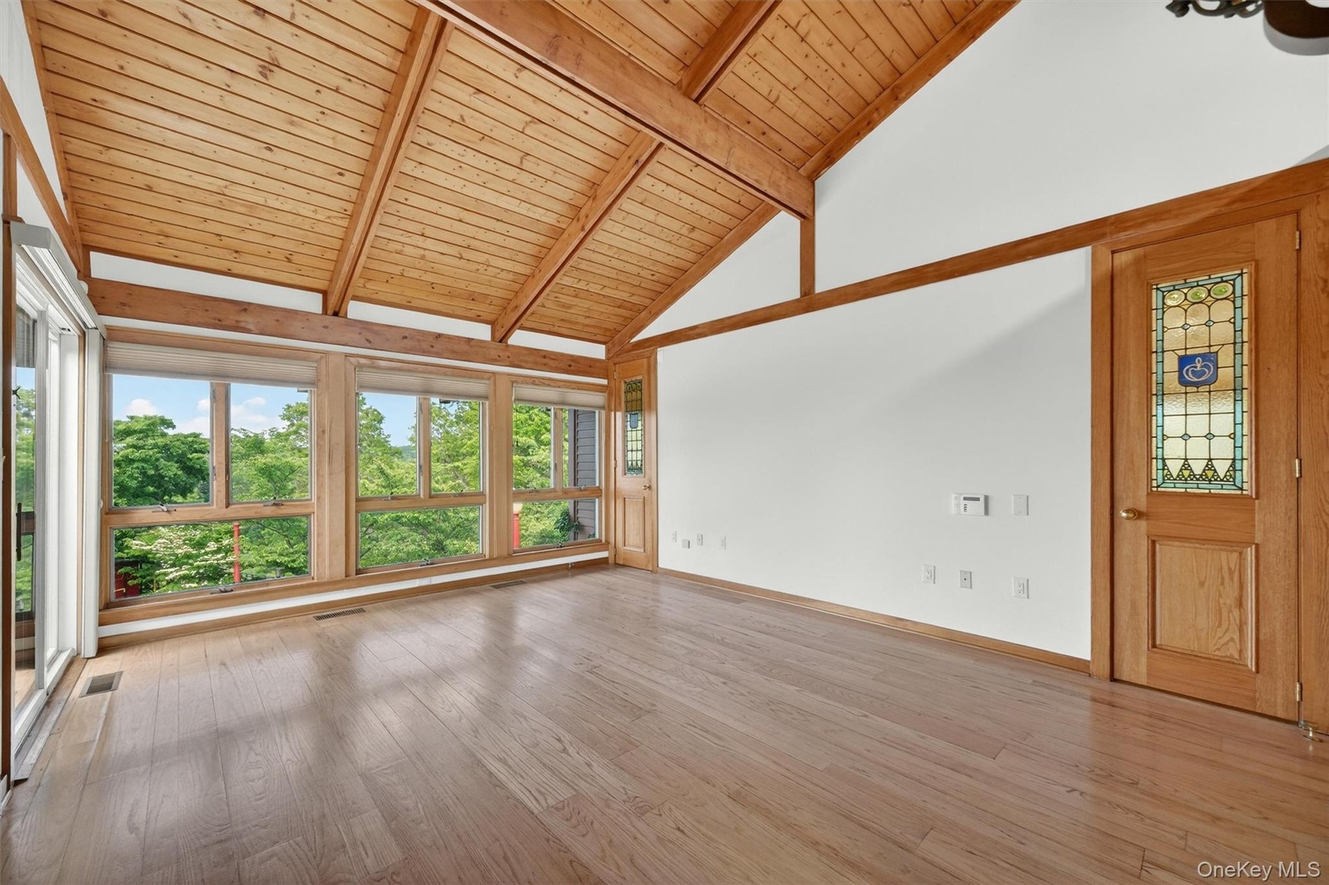 The primary suite is light and bright with walls of windows and a fabulous view of the pool deck, farm and beyond