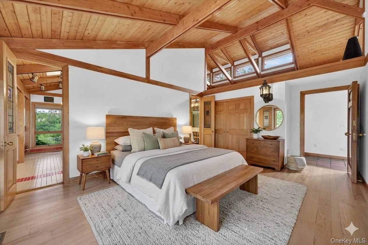 The primary suite is conveniently located on the main level and features a cool open ceiling with wood beams and gleaming floors*virtually staged*