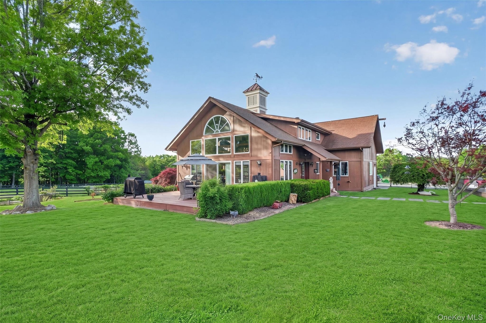 2nd home features a wall of windows to take in the views, a low deck for outdoor entertainment and an expansive lawn with koi pond