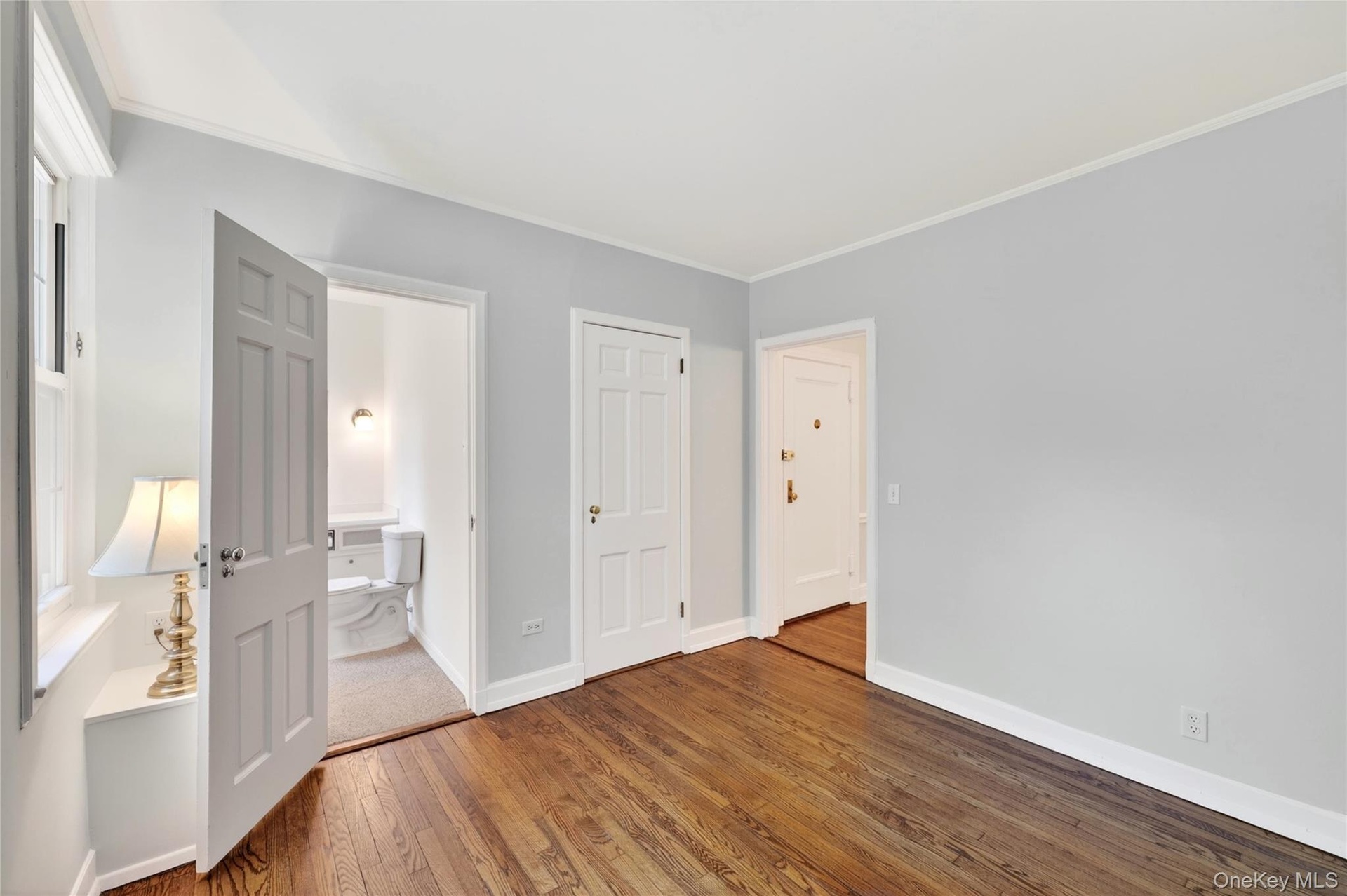 Alternate view of Bedroom #1 with view of the powder room and closet with custom shelving