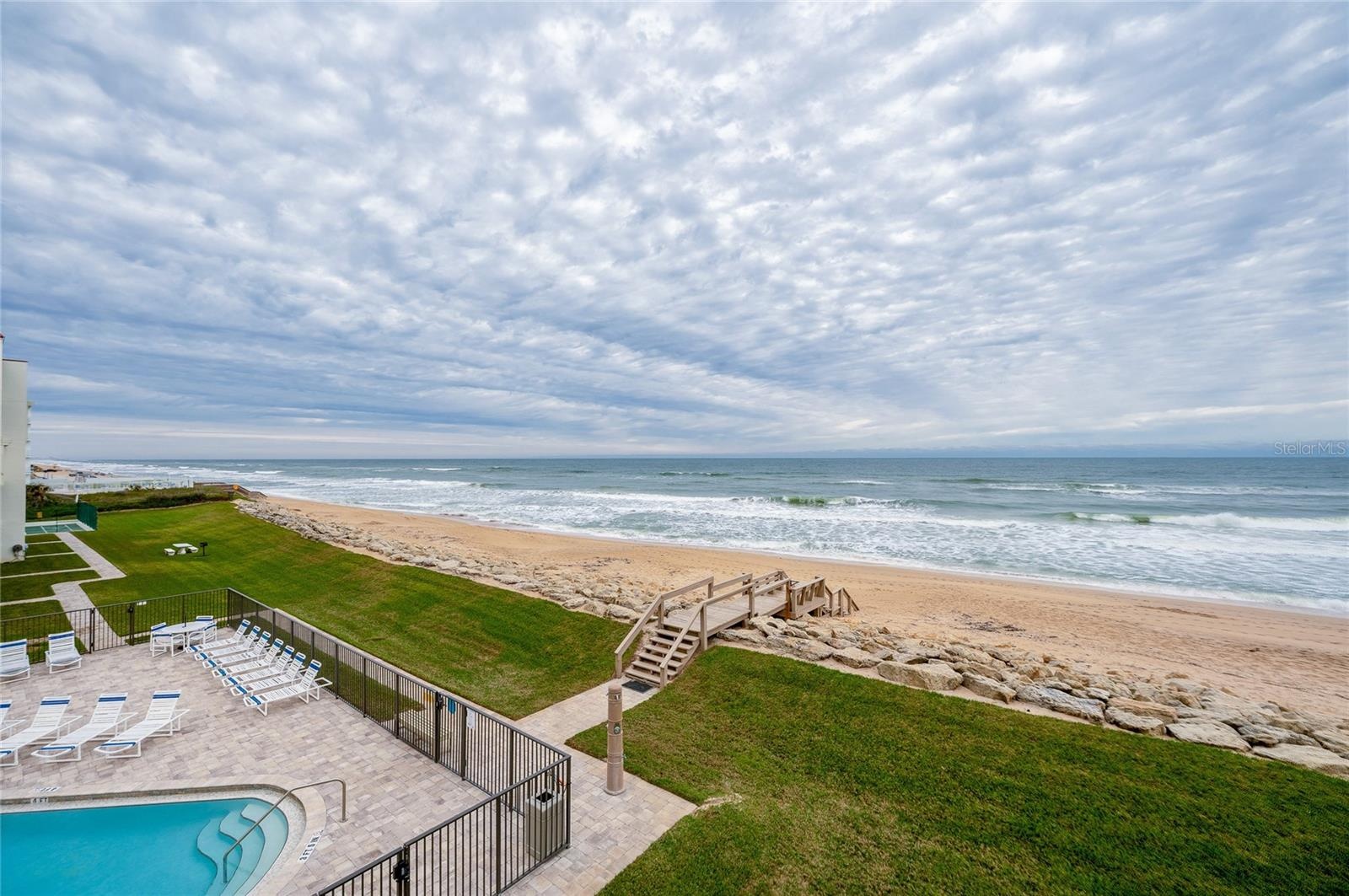Direct beach access from the building leads to soft sand and surf just steps from your door—coastal living at its finest.