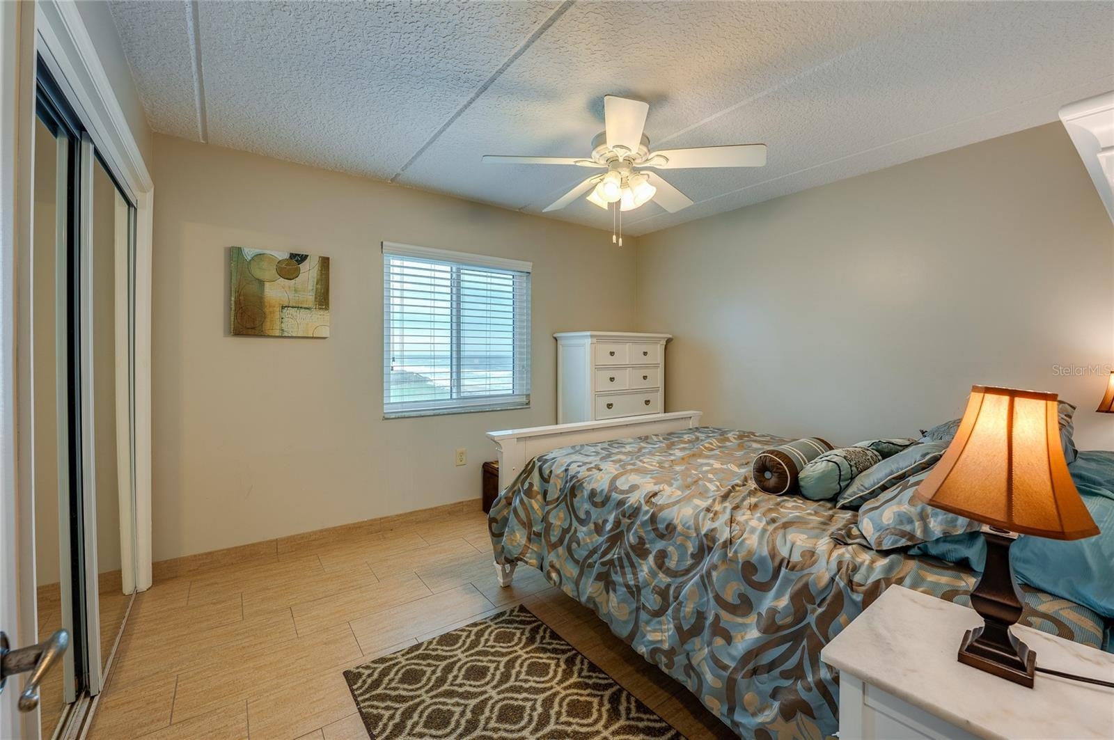 This additional bedroom features soft natural light, a ceiling fan, and ample space, making it ideal for guests or multi-use as a home office or retre