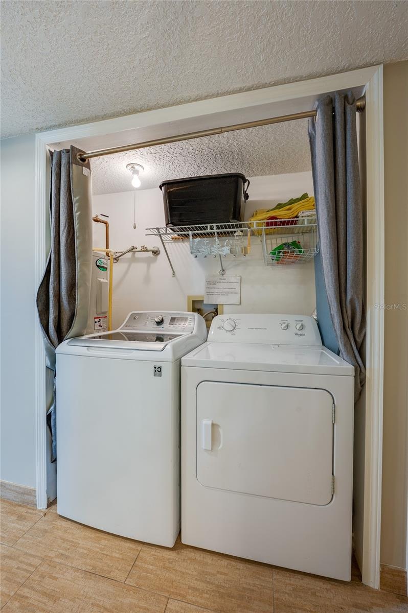 The in-unit laundry area includes a full-size washer and dryer, with open space above—ideal for future DIY shelving or storage customization.