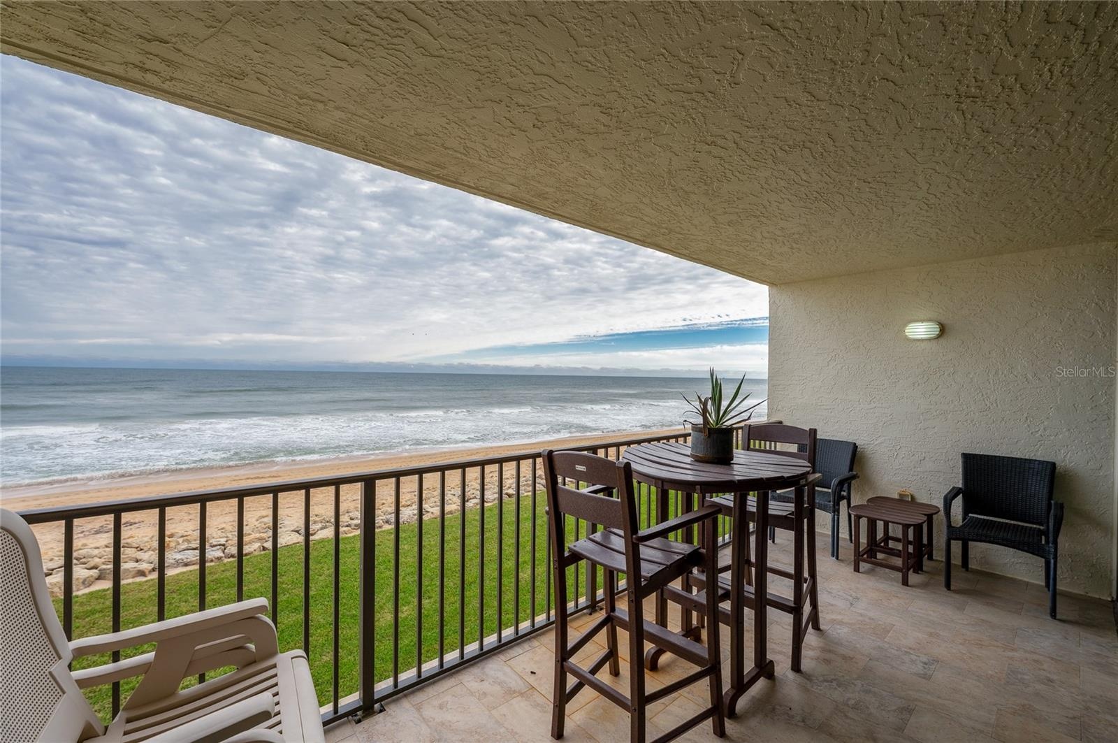 The private covered balcony offers a front-row seat to the Atlantic, with space for dining or lounging while taking in uninterrupted ocean views and t