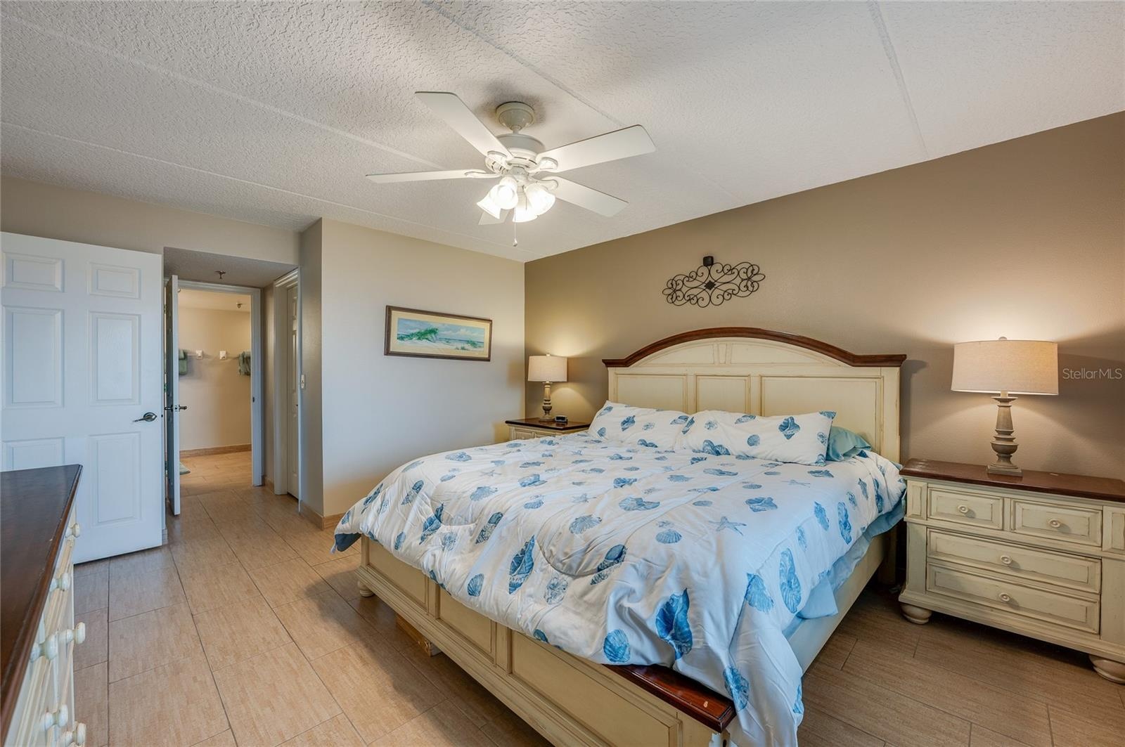 Another angle reveals easy access to the ensuite bathroom and a walk-in layout, with light tile flooring that adds continuity throughout the space.