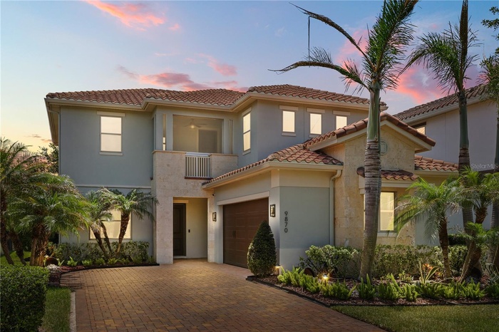 Beautiful exterior of 9870 Mere Parkway at sunset with large driveway and 2-car garage