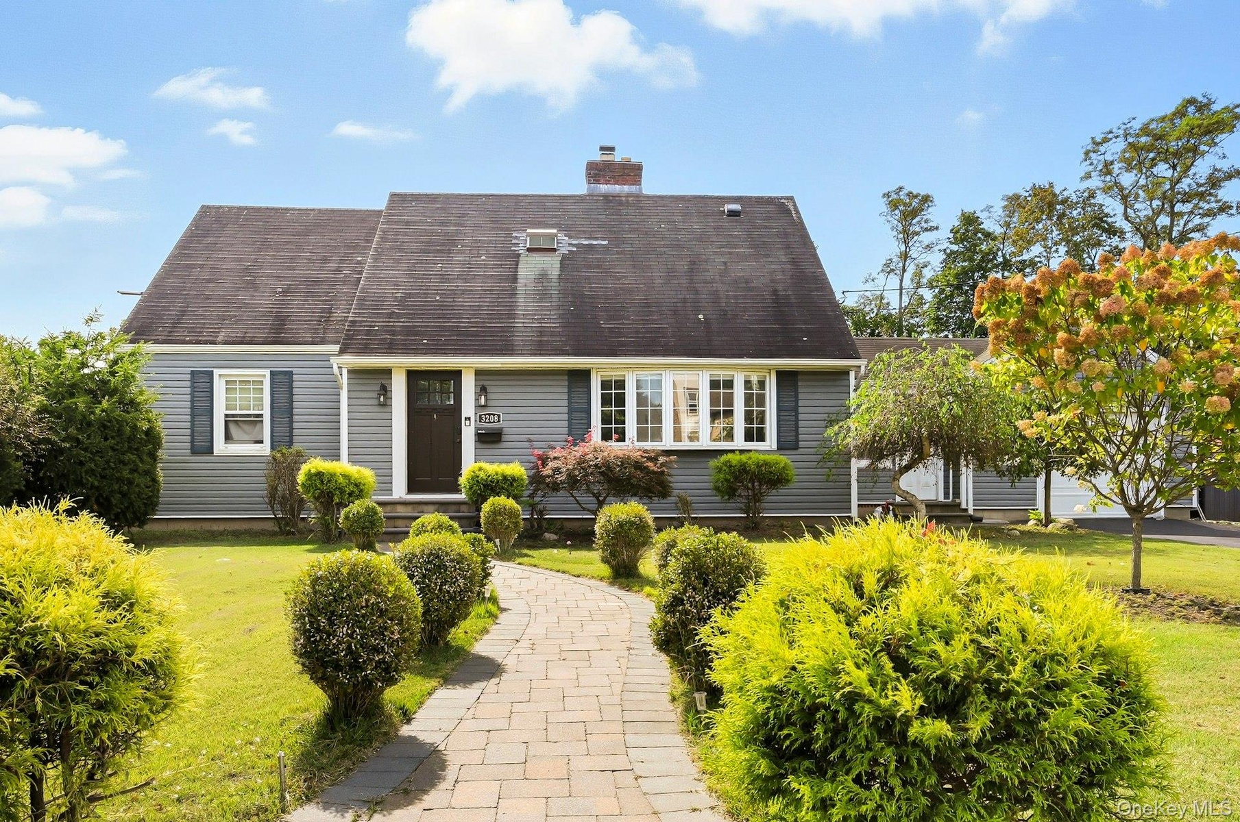 Cape cod house with a front lawn and a chimney