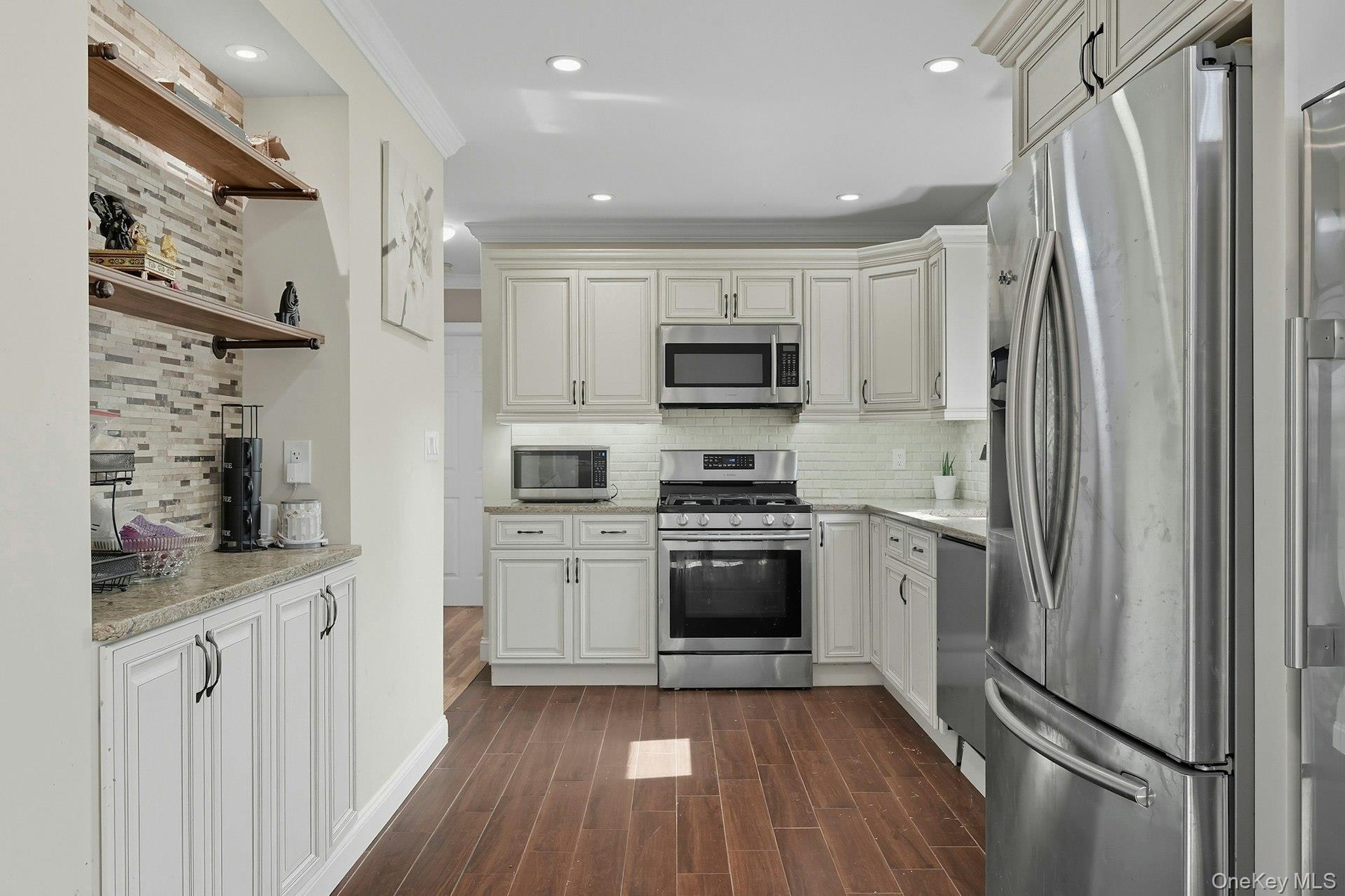 Kitchen featuring built in coffee/tea bar with open shelving above and storage below. Recess lighting.