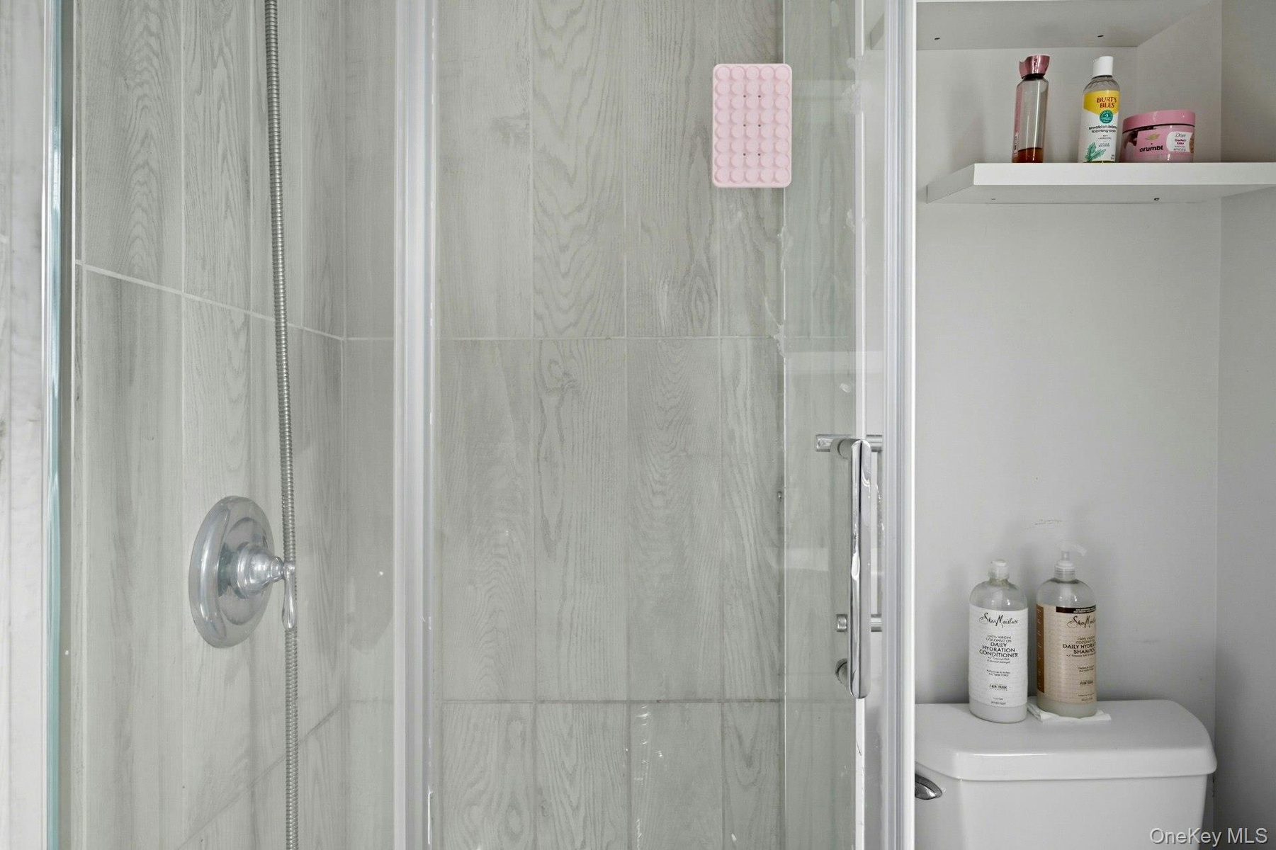 Full bath featuring a shower stall and toilet