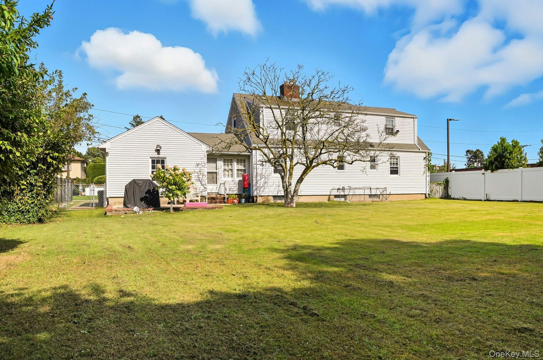 Back of property with a chimney and small patio