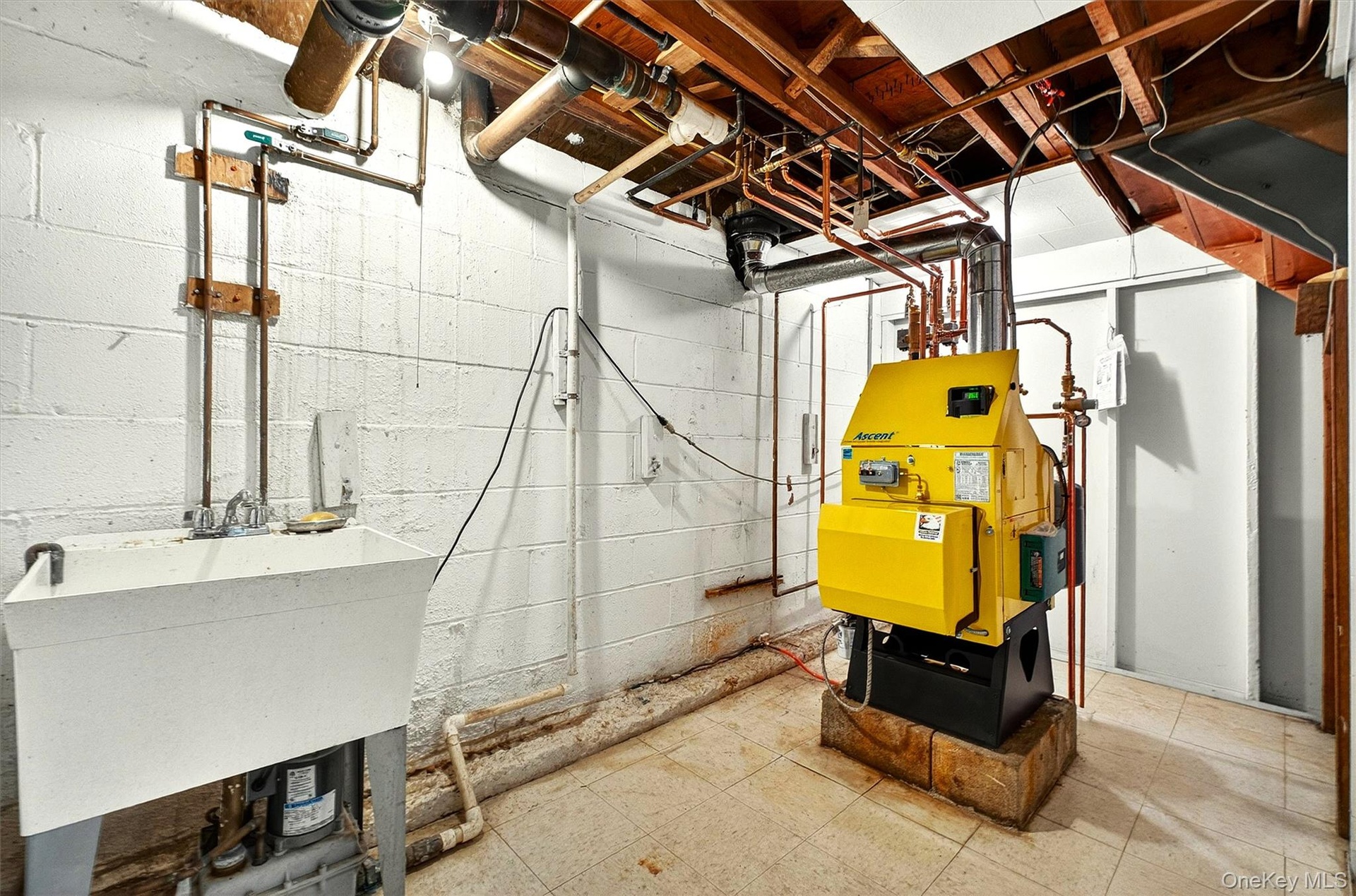 Utility room featuring a laundry sink,  boiler system,