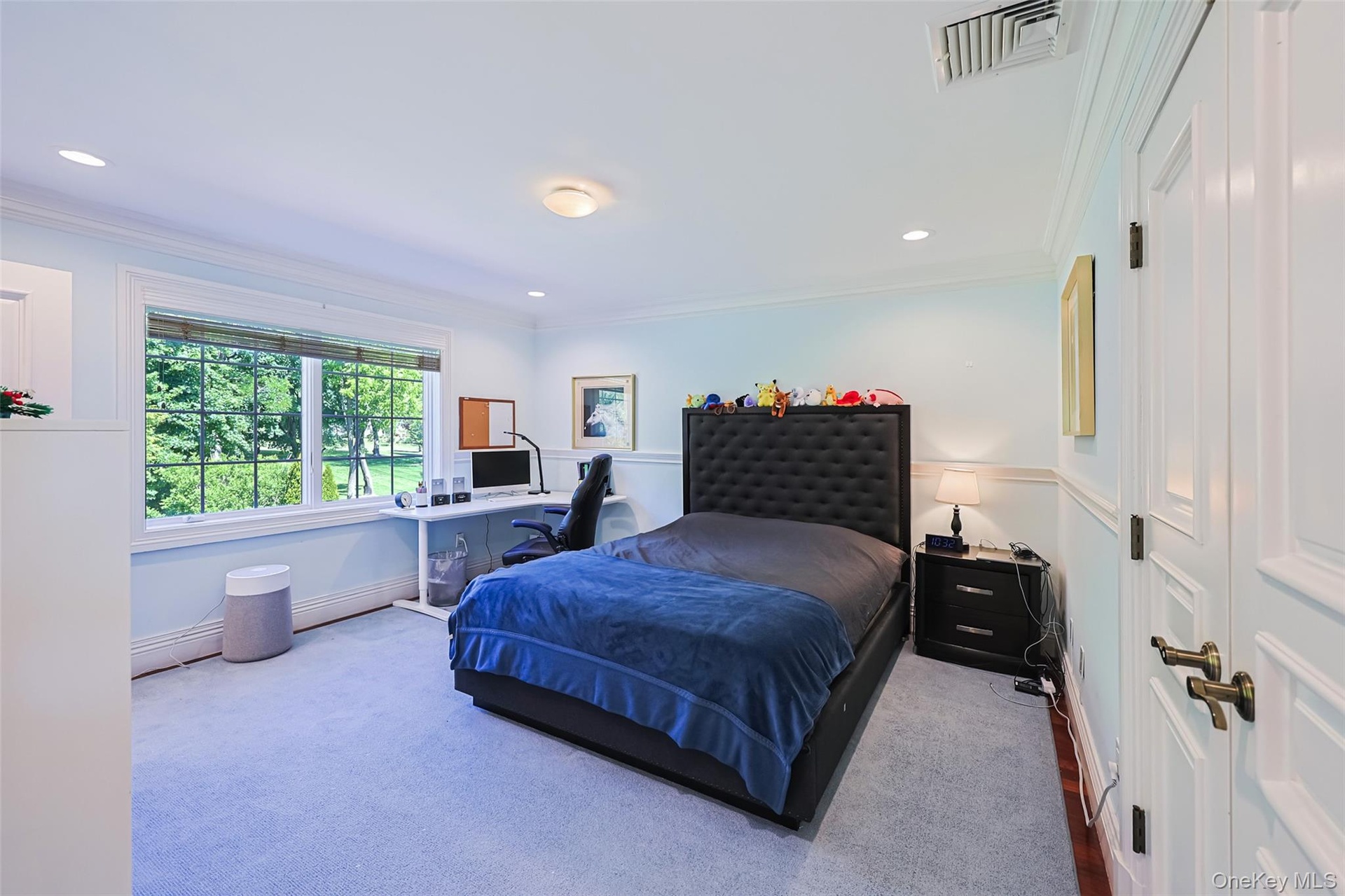 Light-filled room featuring a large window overlooking exterior greenery, crown molding, chair rail molding, recessed lighting, and a paneled interior