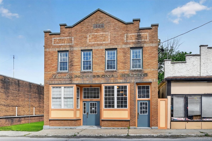 Three-story brick building facade featuring prominent "1926" and "PROFESSIONAL BUILDING" signage