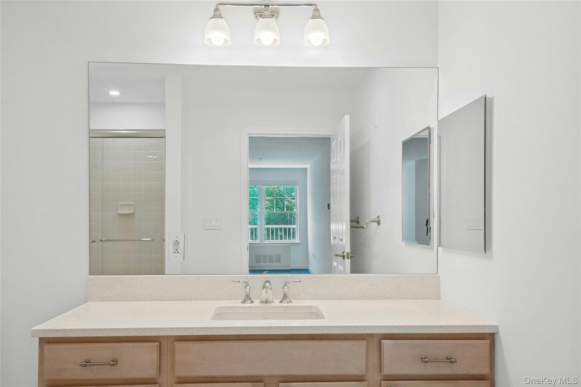 Oversized light wood vanity with new quartz countertops, under mount porcelain sink and Kohler Faucet