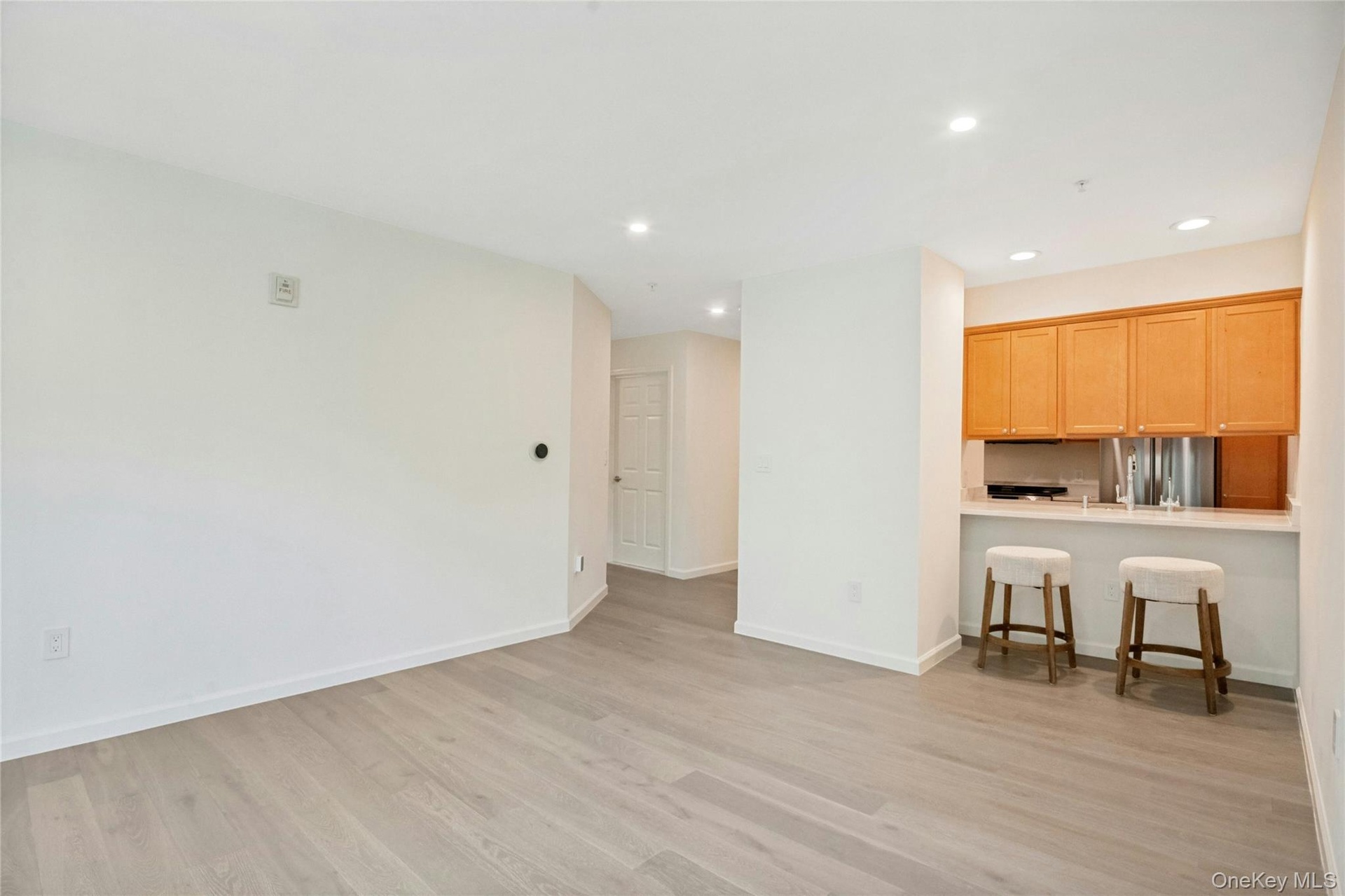 Open-concept living space featuring European white oak flooring and breakfast bar