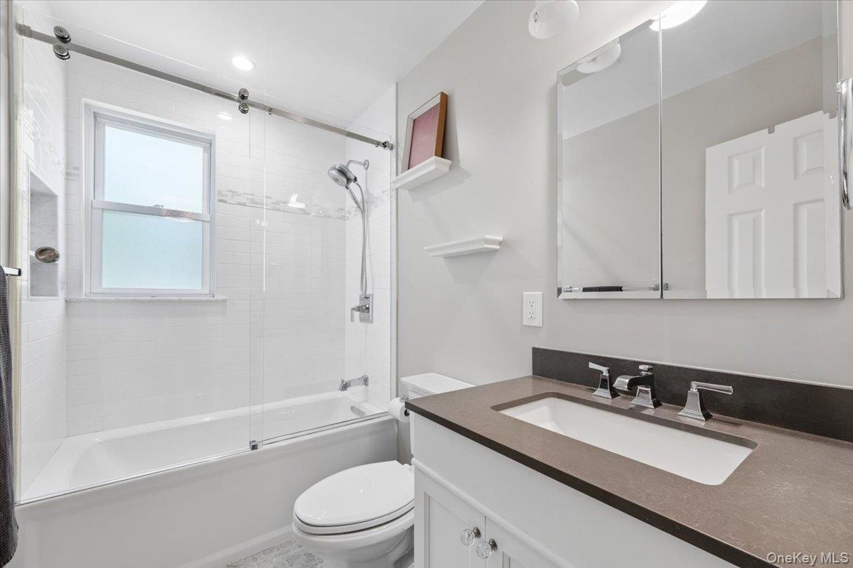 Renovated full bathroom in the hall includes a bathtub