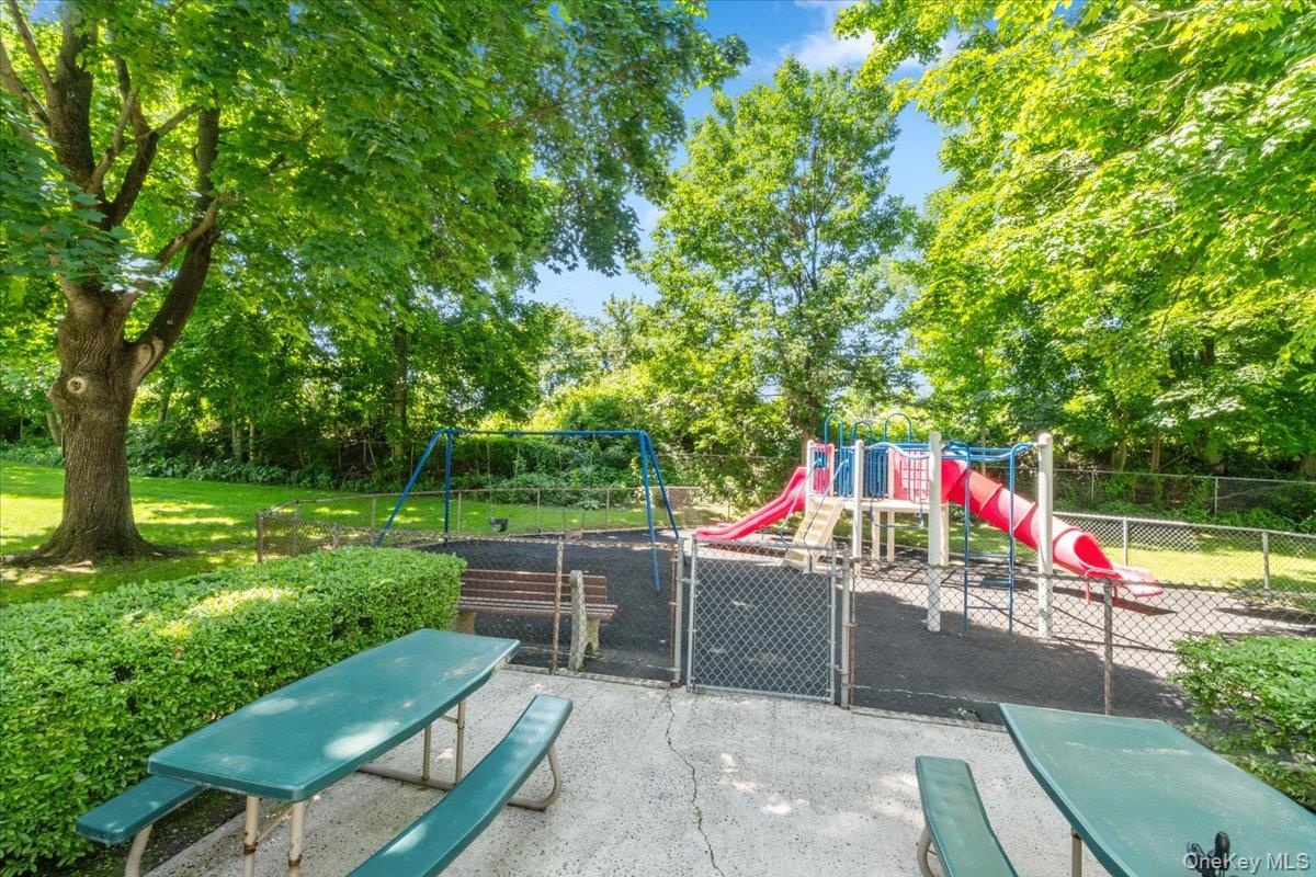 Rye Ridge Condo Playground and patio area with outdoor table seating area