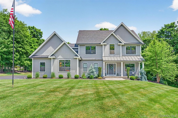 Contemporary gray siding exterior with multiple gables and a covered front porch featuring white columns