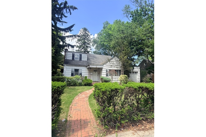 Traditional-style residence featuring white siding and a dormer window