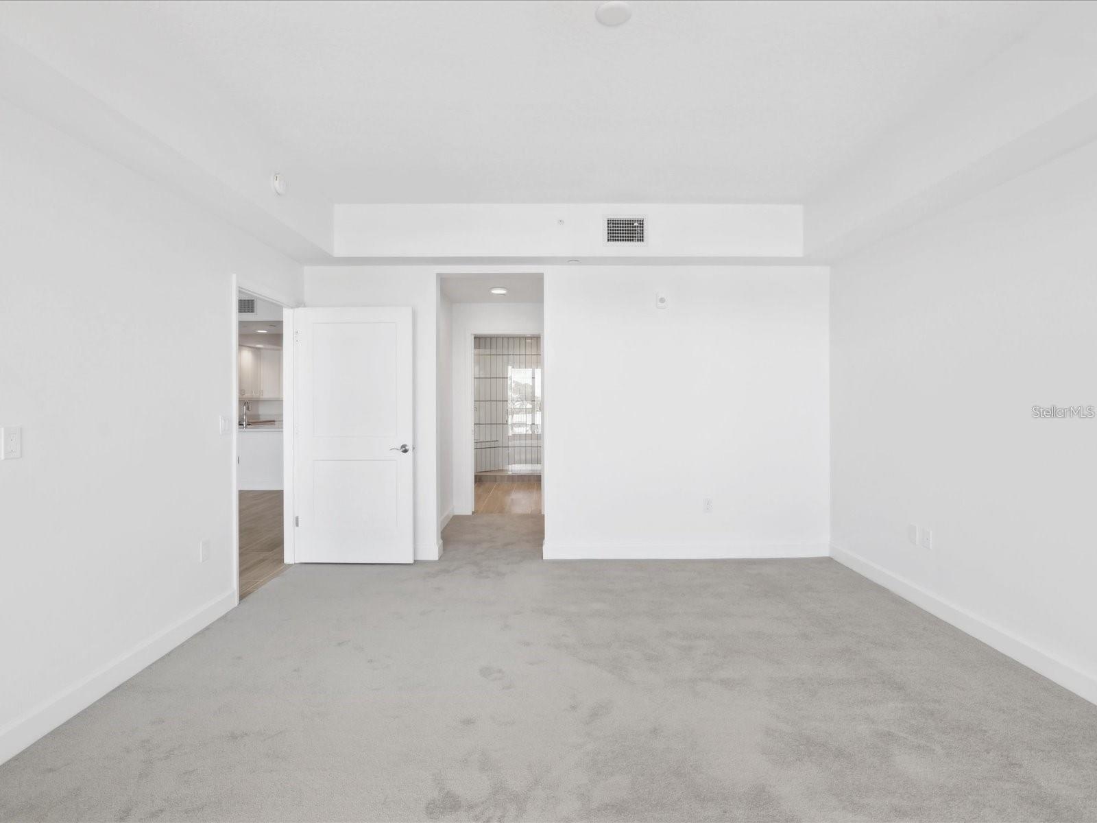 Primary bedroom looking to hall to private bath