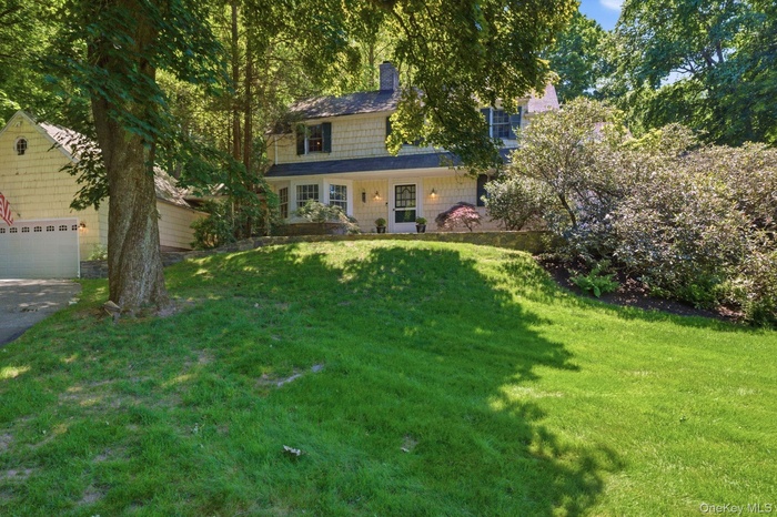 Welcome to 2 Turner Drive, a 1934 Chappaqua Colonial nestled in the heart of Seven Bridges on nearly three-quarters of an acre, framed by mature plant
