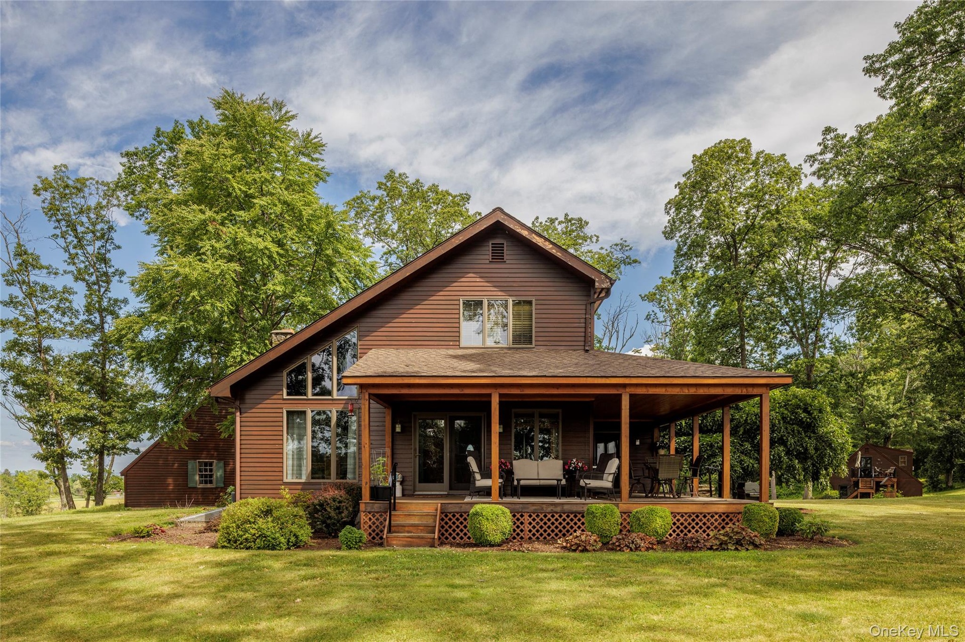 Back of property with a lawn, covered porch, and a chimney