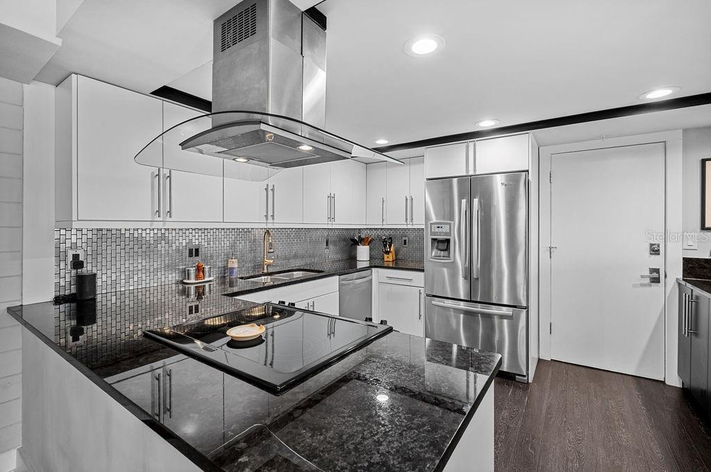 Granite counter tops and enclosed vent hood keep the sleek design in the kitchen.