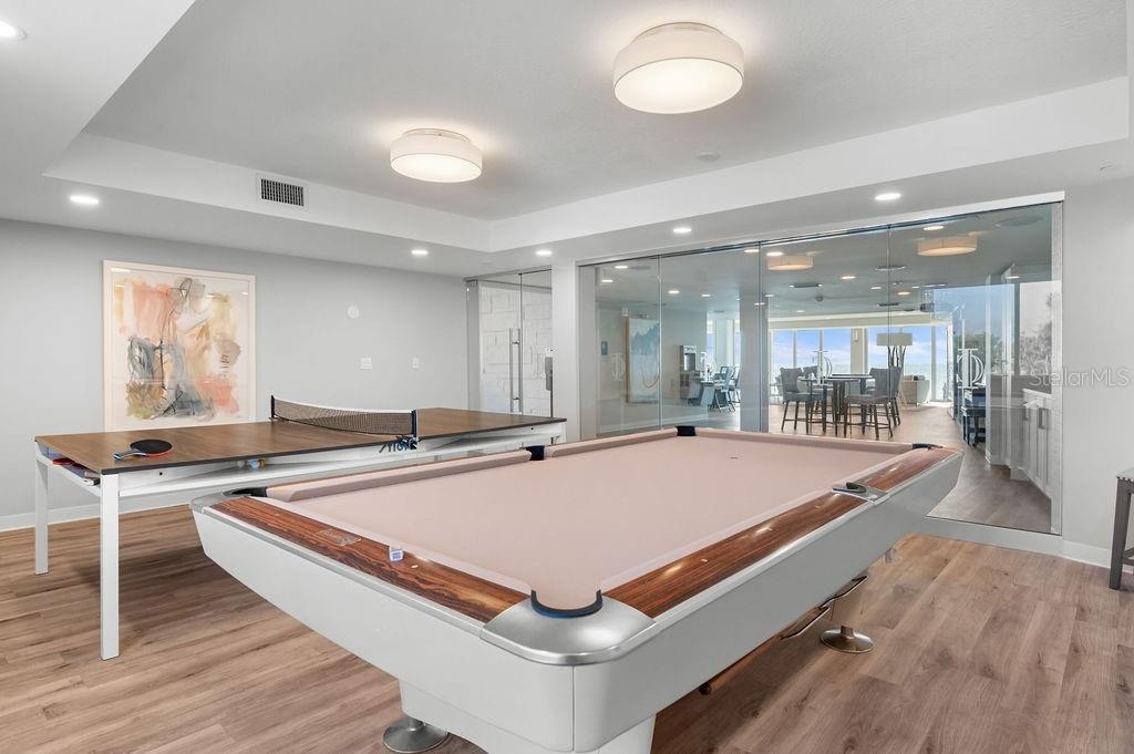 The recreation room hosts a pool table and table tennis area