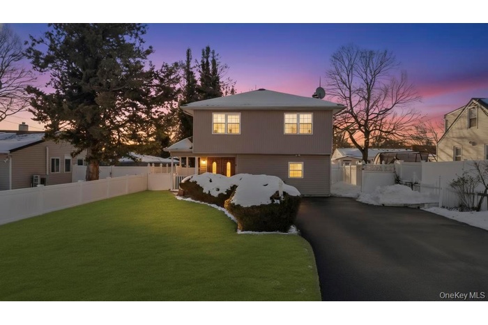 View of front of house featuring driveway and a gate