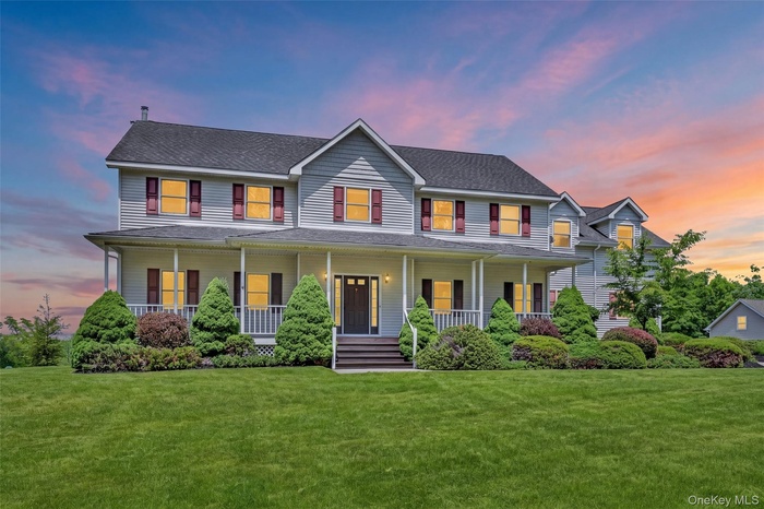Two-story residence featuring light gray siding, dark roof shingles, and red window shutters