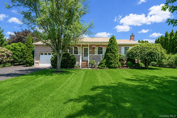 Ranch-style residence featuring a single-car garage, newly paved large driveway, covered front porch