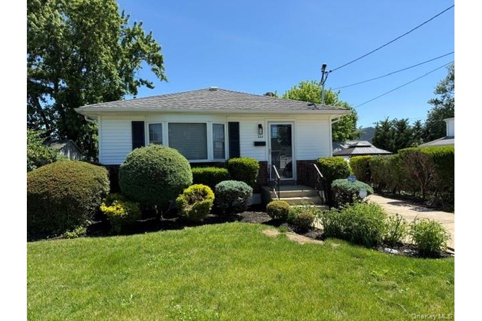 White siding exterior with black window shutters and a gabled roof