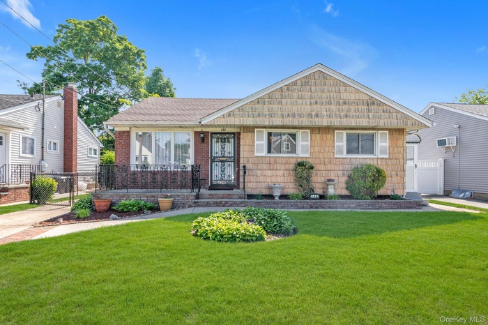 Ranch style residence featuring a brick facade and shake siding
