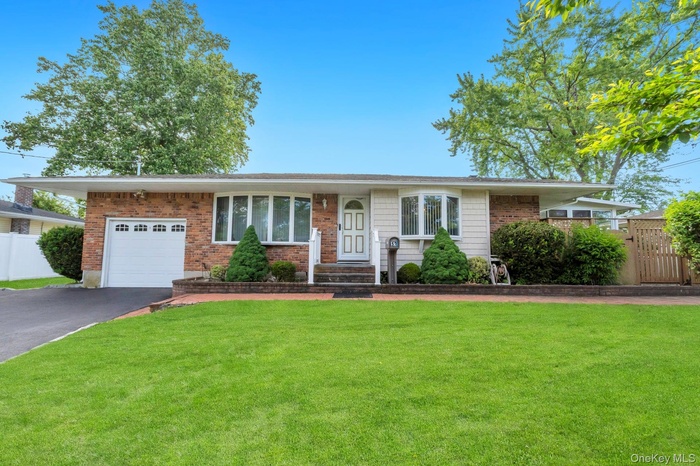 Ranch-style residence featuring a brick facade, bay windows, and a manicured front lawn