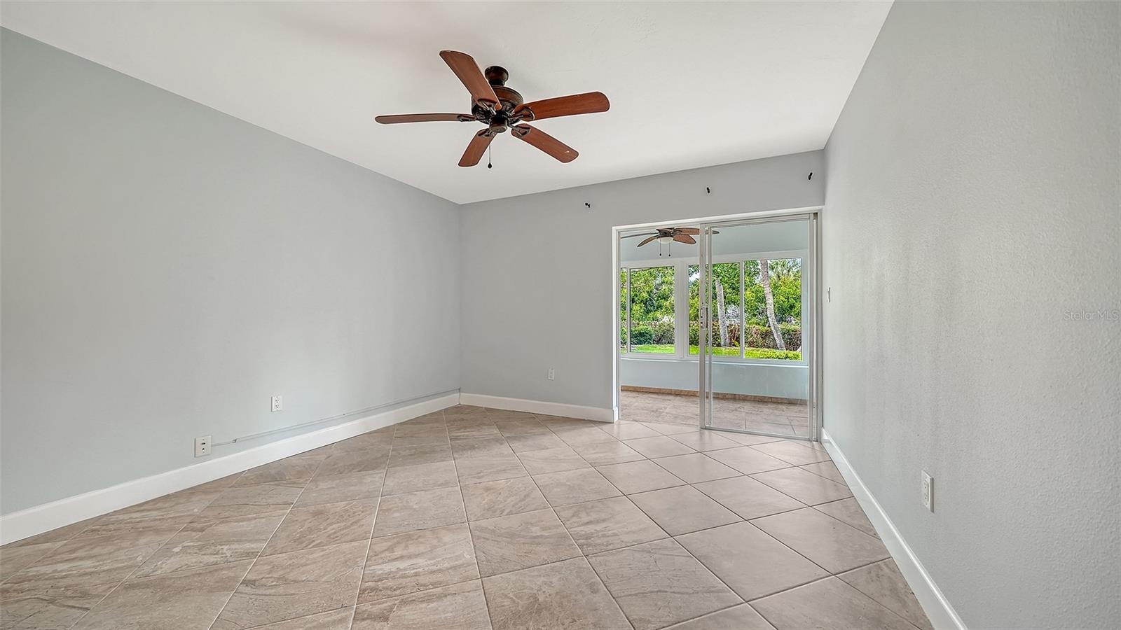 Guest bedroom also features floor to ceiling sliders leading to the lanai.