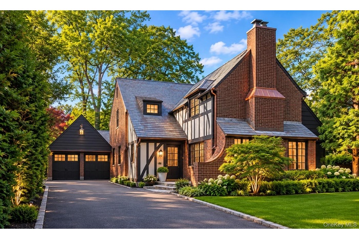 Brick and half-timber exterior featuring a slate roof and copper chimney flashing