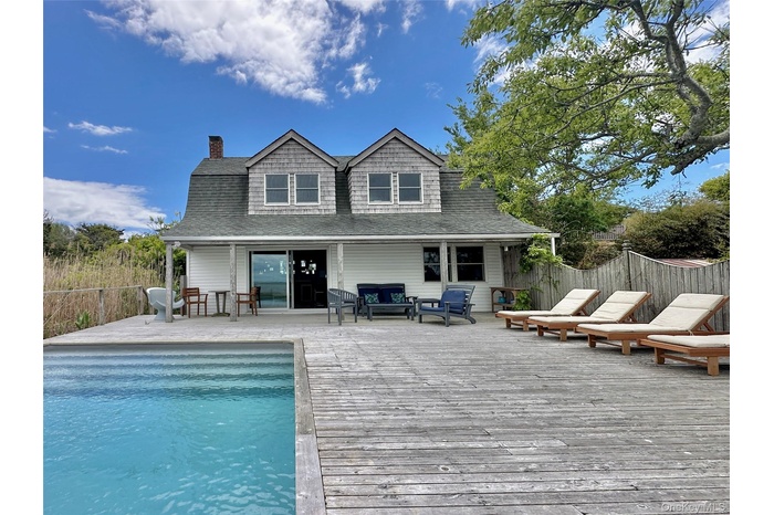 Rear view of property with a deck, a chimney, roof with shingles, and outdoor lounge area