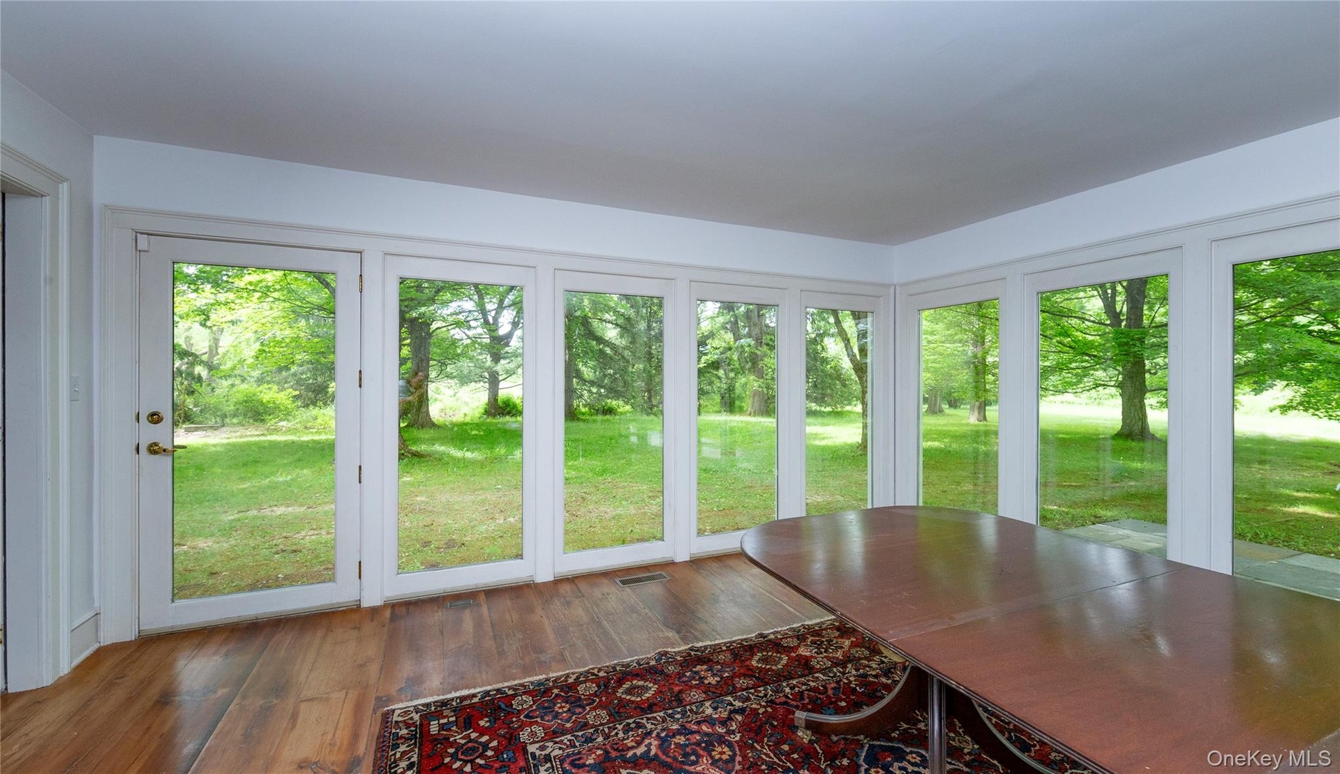 Room featuring wood-finish flooring and a series of floor-to-ceiling windows