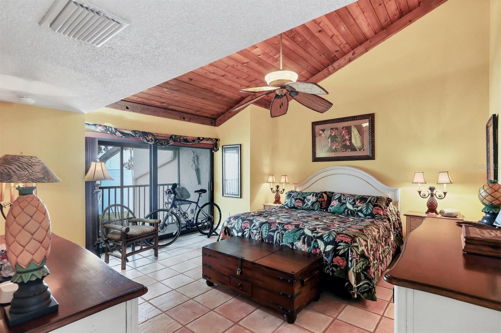 Warm & Inviting Primary Suite with Terracotta Tile, Wood Ceiling Detail, and Private Patio with Full Bay View