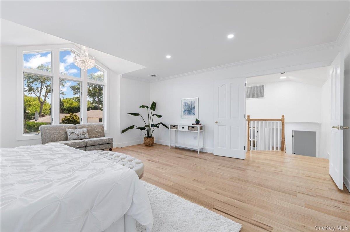 Bedroom featuring ornamental molding, wood finished floors, a chandelier, and recessed lighting