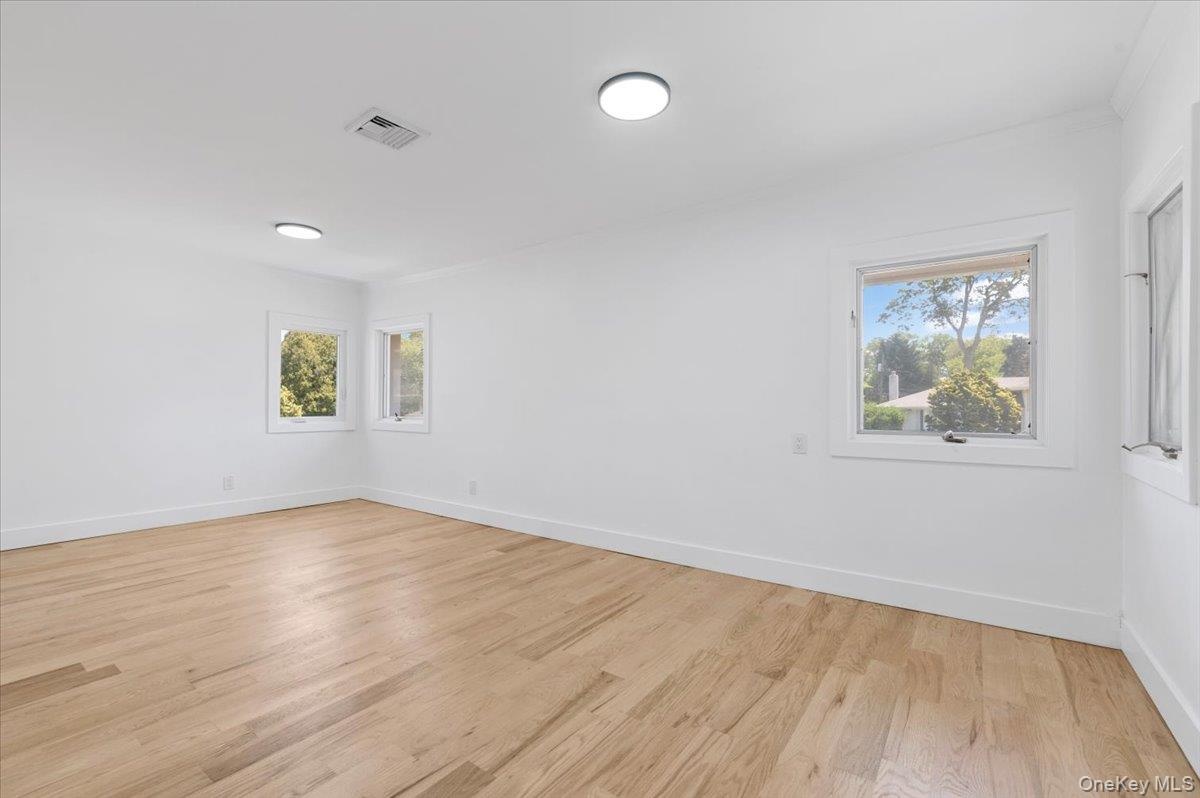 Unfurnished room featuring healthy amount of natural light and light wood-style flooring