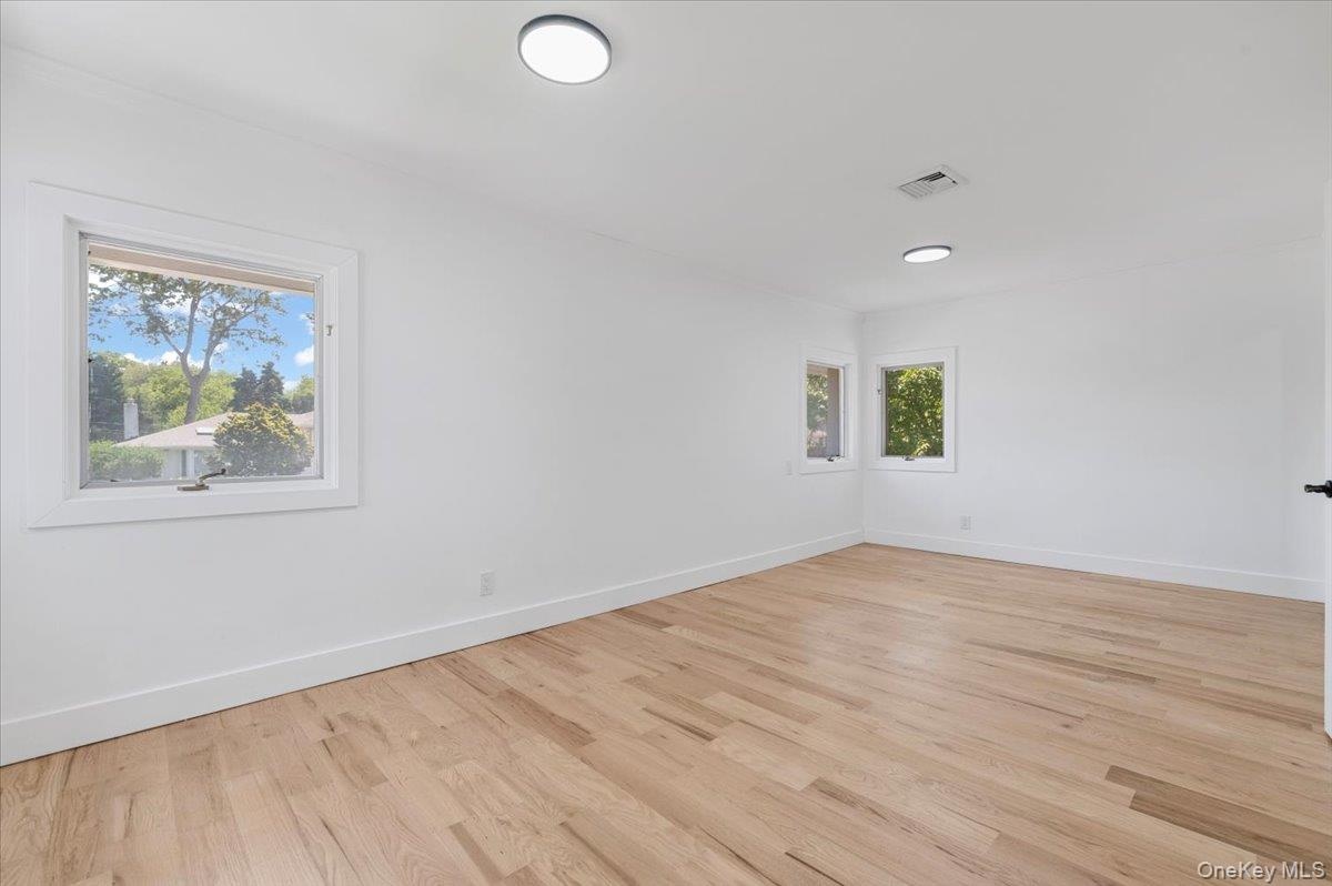Unfurnished room featuring light wood-type flooring and baseboards