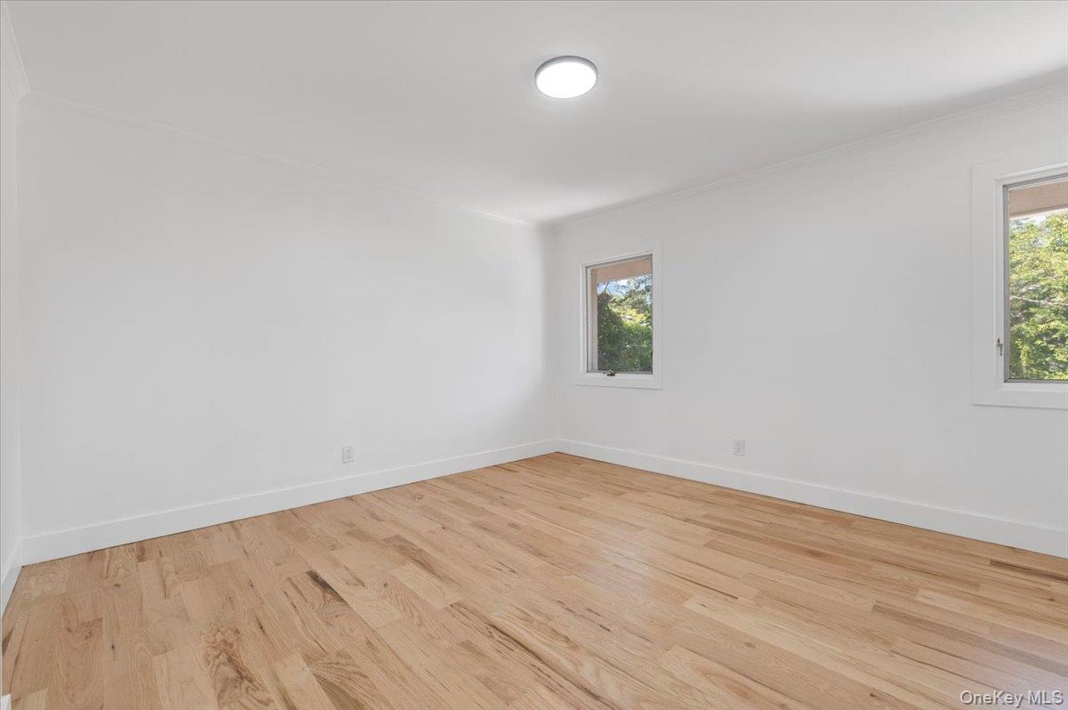 Unfurnished room featuring wood finished floors and ornamental molding