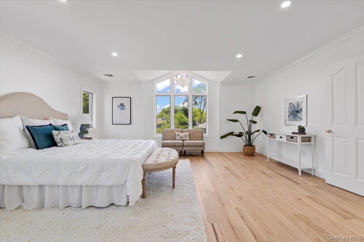 Bedroom featuring light wood finished floors, crown molding, and recessed lighting