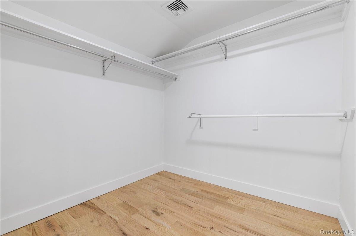 Spacious closet featuring vaulted ceiling and wood finished floors