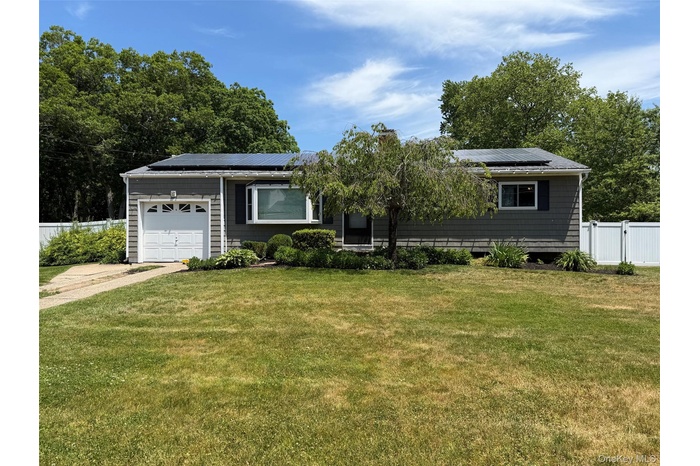 Ranch-style residence featuring grey siding, a front-facing garage with a white door, and a bay window