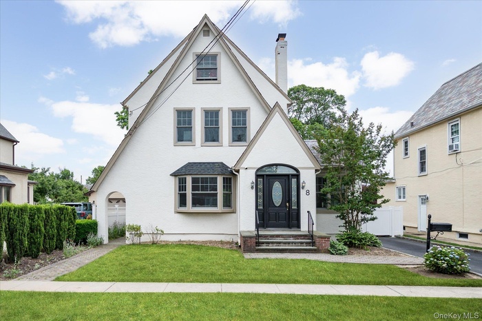 Gable-roof exterior with white stucco finish and contrasting trim